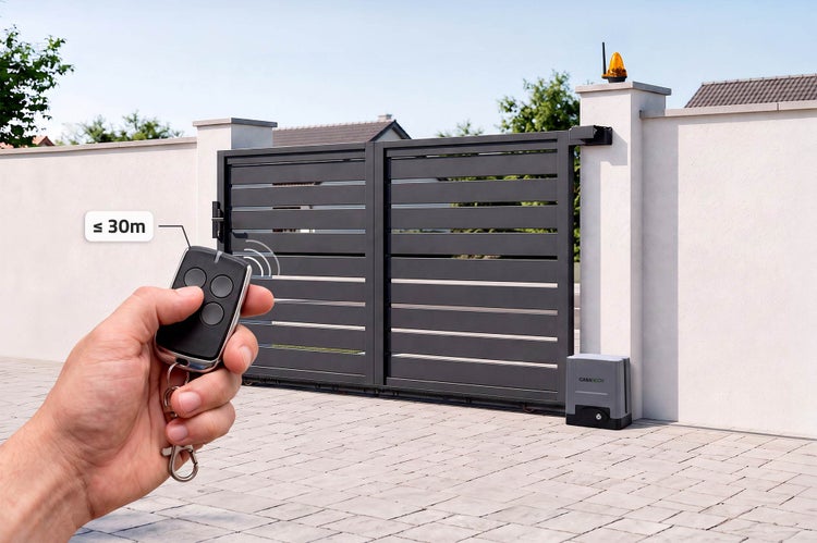 Hand gehaltene Fernbedienung steuert ein modernes elektrisches Schiebetor vor einer Einfahrt mit einer Reichweite von bis zu 30 Metern.