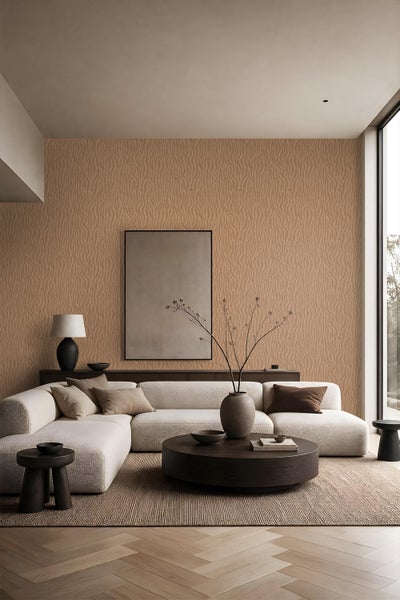 Wohnzimmer mit Vliestapete mit wellenförmigem Strukturmuster in einem hellen Raum mit modernem Sofa und runden Beistelltischen.
