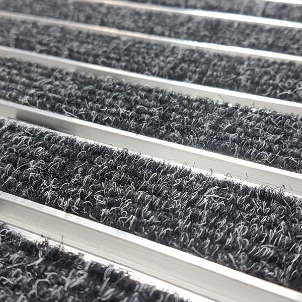 Detailaufnahme einer Schmutzfangmatte mit Aluminiumprofilen und textilem Einsatz