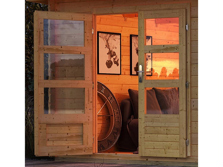 Offene Doppeltür eines Gartenhauses aus Holz mit Glaseinsätzen und Blick in einen hell beleuchteten Innenraum mit Sofa und Dekoration.
