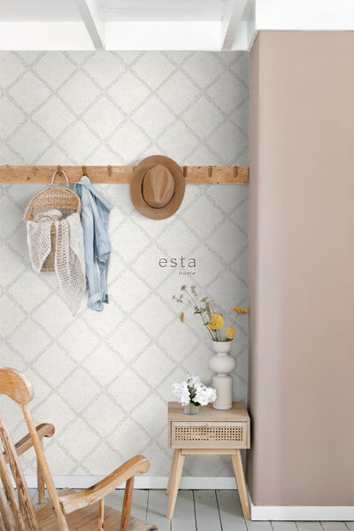 Dekoratives Interieur mit gemusterten Tapeten, Holzgarderobe und Beistelltisch.