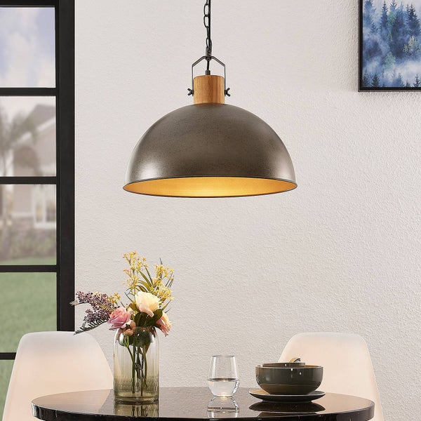 Industrielle Pendelleuchte mit grauem Metallschirm und Holzdetail über einem Esstisch mit Blumen und Geschirr in einem hellen, modernen Raum.