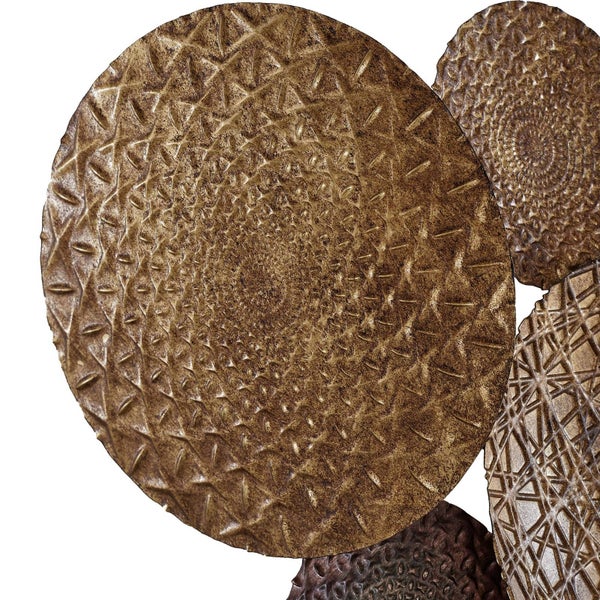 Detailansicht einer Wanddekoration aus Metall mit überlappenden runden Platten und strukturierten geometrischen Mustern.