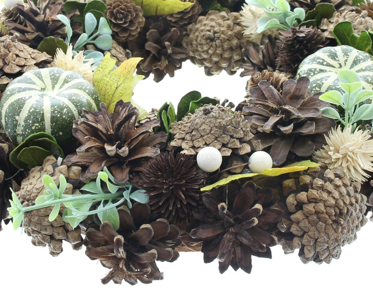 Herbstlicher Türkranz mit Kiefernzapfen, Zierkürbissen und künstlichen Blättern für die herbstliche Dekoration.