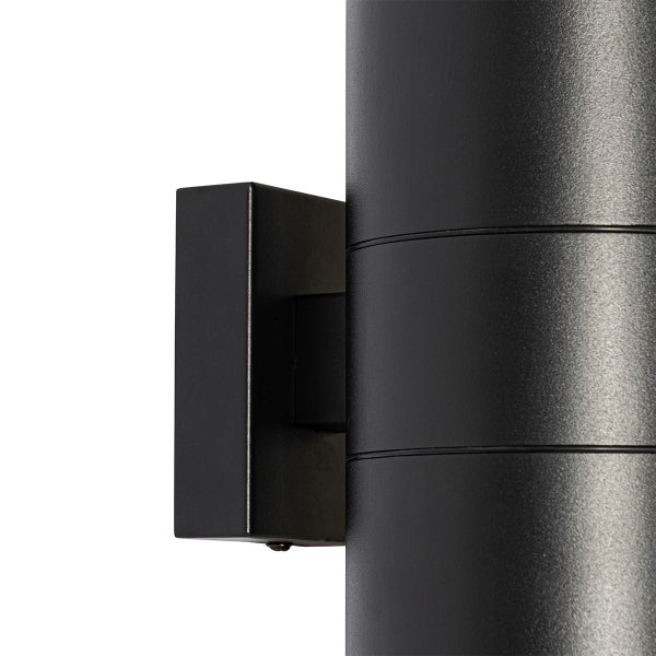 Nahaufnahme einer schwarzen zylindrischen Wandleuchte aus Metall mit Wandhalterung.