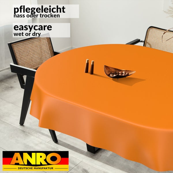 Pflegeleichte runde orange Tischdecke auf einem runden Tisch mit zwei Rattanstühlen in einem hellen Esszimmer. ANRO Logo.