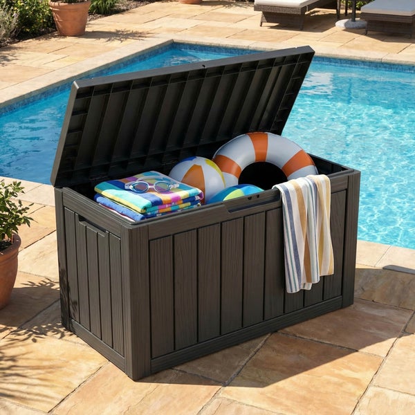Geöffnete Gartenbox aus Kunststoff in Holzoptik mit Poolzubehör neben einem Schwimmbecken auf der Terrasse.