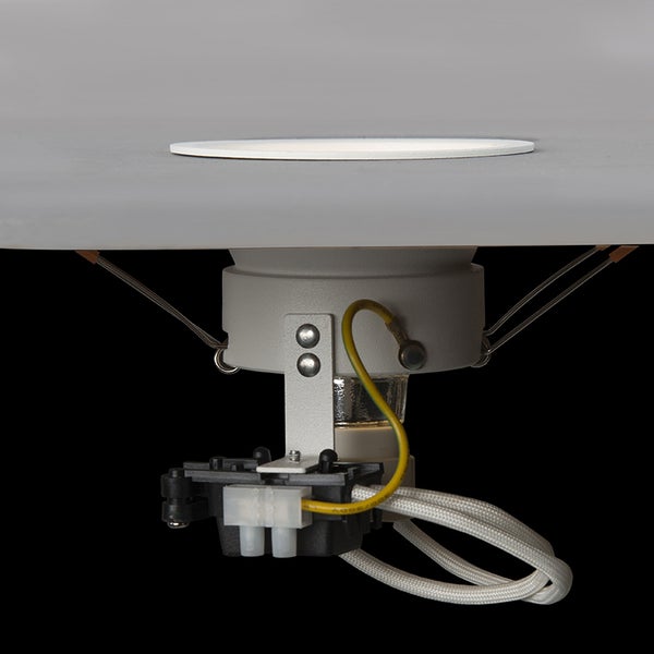 Einbauleuchte von der Seite, montiert in einer Platte, mit sichtbarem Gehäuse, Haltefedern und elektrischen Anschlüssen.