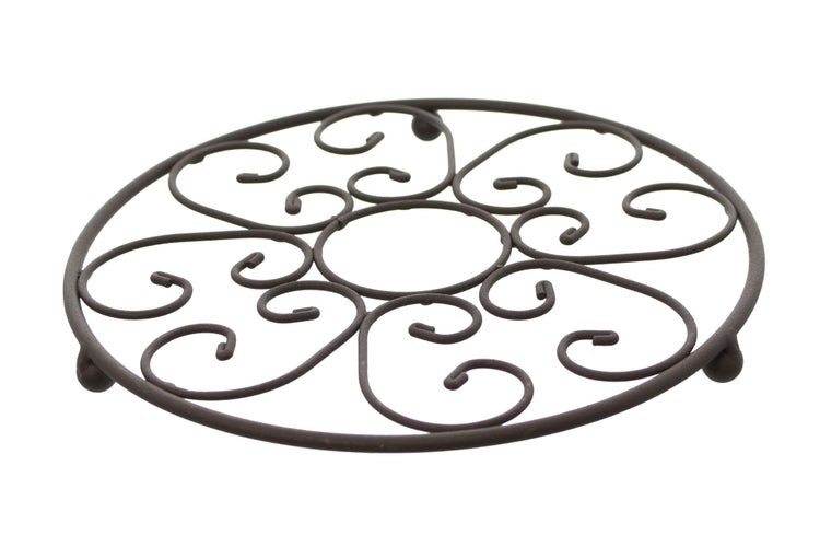 Dekorative Topfuntersetzer aus Metall auf einem Holztisch mit Kochtopf