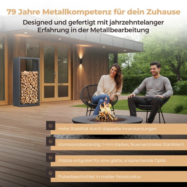 Ein Paar sitzt auf einer Holzterrasse an einer brennenden Feuerschale neben einem gefüllten Kaminholzregal aus Metall vor einem modernen Holzhaus.