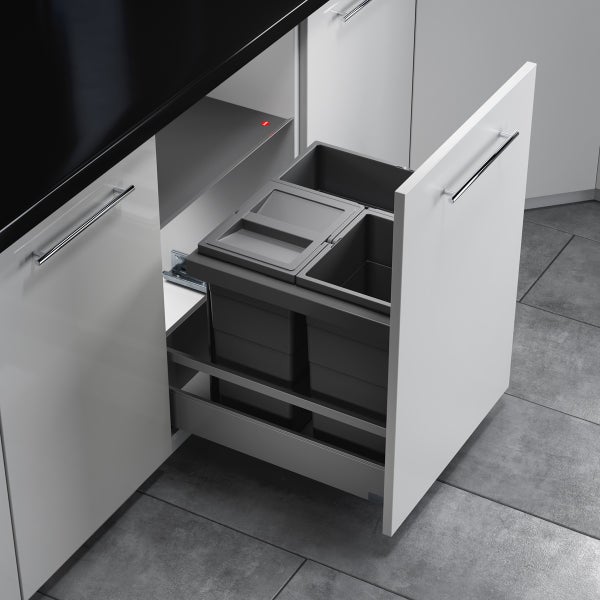 Ausziehbarer Müllsammler in einem Küchenunterschrank mit drei grauen Abfallbehältern aus Kunststoff zur Mülltrennung.