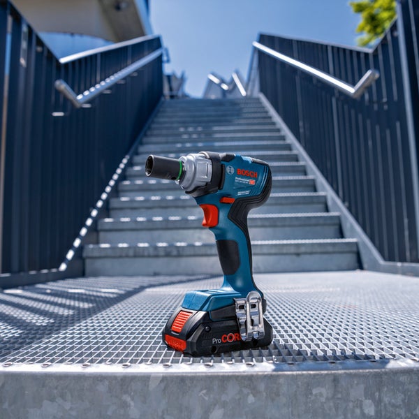 Bosch Professional Akku-Drehschlagschrauber GDS 18 Volt-330 HC mit ProCORE 18 Volt Akku auf einer Metallgittertreppe im hellen Außenbereich.