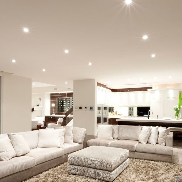 Heller, offener Wohn- und Küchenbereich mit vielen Einbaustrahlern in der Decke für eine gleichmäßige und moderne Beleuchtung.