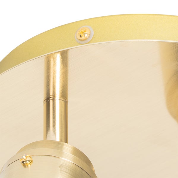 Detailaufnahme einer goldenen Deckenleuchte mit Schraubenbefestigung