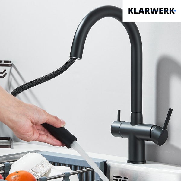 Moderne Küchenarmatur in Schwarz matt mit hohem Auslauf und herausziehbarer Geschirrbrause in Gebrauch. KLARWERK Logo.