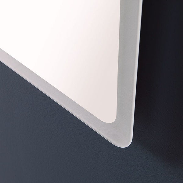 Detailaufnahme der Kante eines Badspiegels mit mattiertem Rand und abgerundeter Ecke.