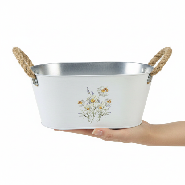 Ovaler Pflanztopf aus Metall mit Seilgriffen und Gänseblümchen-Motiv.