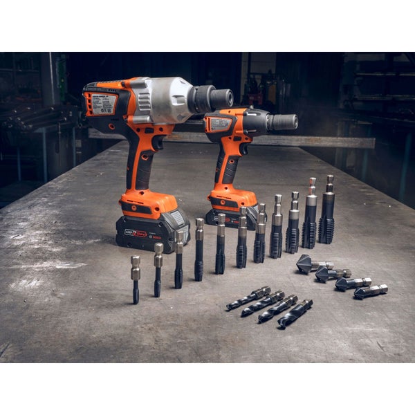 Zwei Akku-Schlagschrauber und ein Set Bohrer und Gewindebohrer auf einem Tisch