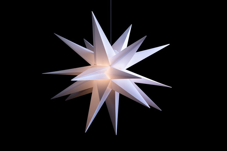 Balkonszene mit zwei Stühlen, Sternenlichtern und Kerzen bei Nacht