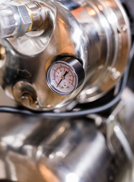 Nahaufnahme einer Hauswasserpumpe mit Manometer zur Druckmessung.