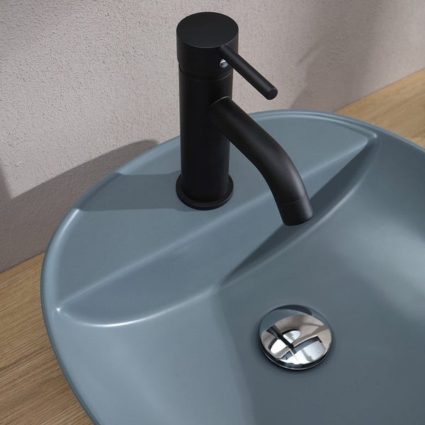 Schwarze matte Waschtischarmatur mit Einhebelmischer auf einem mattblauen Keramik-Aufsatzwaschbecken im modernen Badezimmer.