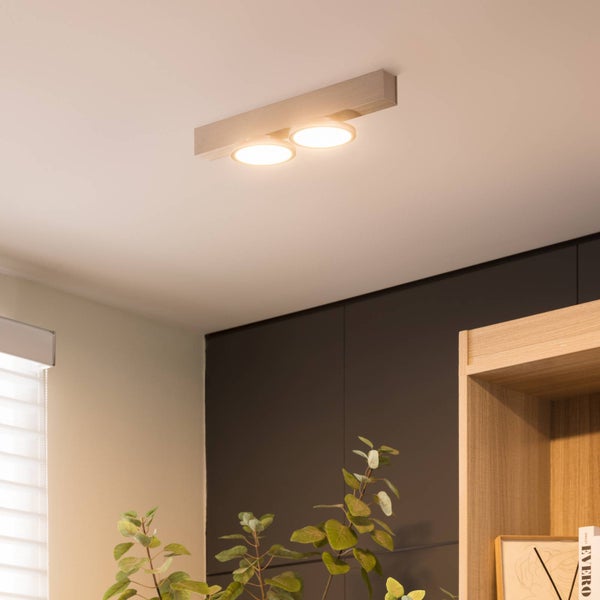 Zwei Deckenleuchten in Holzoptik beleuchten einen Raum.