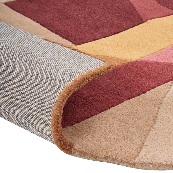 Moderner Teppich mit geometrischem Muster, Nahaufnahme von Flor und gewebtem Rücken mit umgeknickter Ecke.