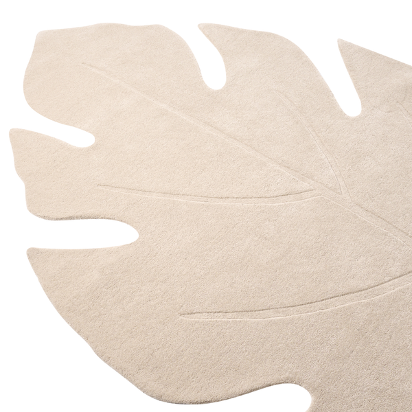 Beiger Teppich in Form eines Monstera-Blattes mit sichtbarer Blattaderstruktur.