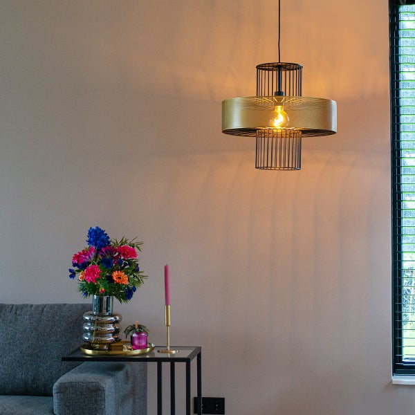 Innenraum mit einer Pendelleuchte, einem Tisch mit Dekoration und einem Sofa