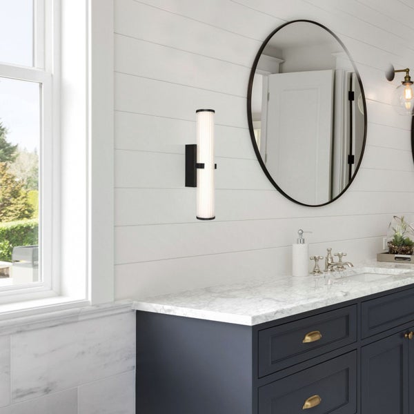 Badezimmer mit Waschbeckenunterschrank, Spiegel und Wandleuchte