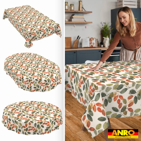 Abwaschbare Tischdecke mit Blättermuster in eckiger, ovaler und runder Form. Frau glättet die Decke in einer hellen Küche. ANRO Logo.