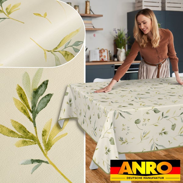 Tischdecke mit Blättermuster auf einem Tisch, Frau im Hintergrund und ANRO Deutsche Manufaktur Logo