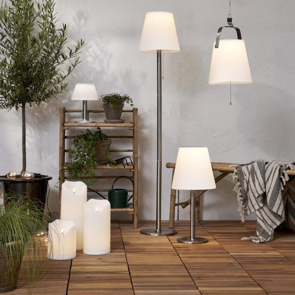 Terrassenszene mit Stehlampe, Tischleuchten, Hängeleuchte, LED Kerzen und Pflanzen auf einem Holzdeck