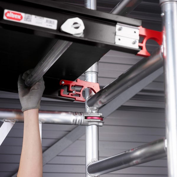 Aufbau eines Altrex Gerüsts mit einer Person, die ein Teil montiert.