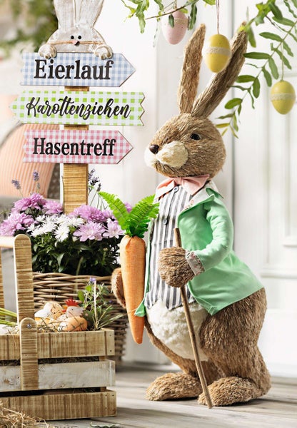 Dekorative Osterdekoration mit Osterhase, Wegweiser und Blumenarrangements