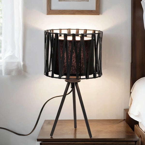 Tischleuchte mit Stoffschirm und Stativfuß auf einem Nachttisch
