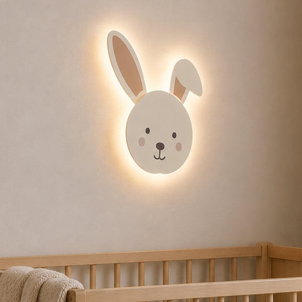 Wandleuchte in Hasenform für Kinderzimmer mit indirekter Beleuchtung über einem Holzkinderbett.