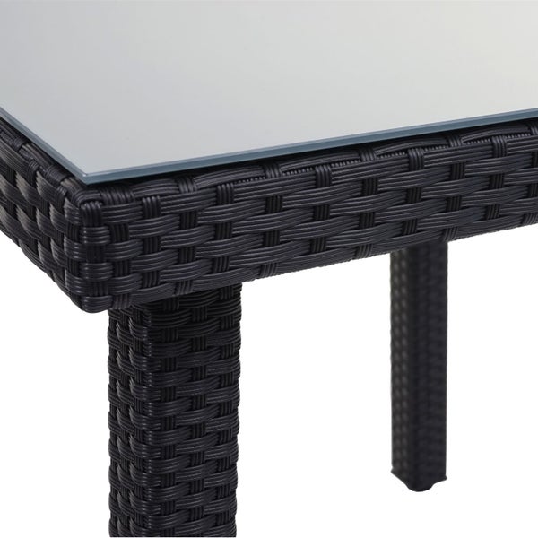 Detailansicht eines Gartentisches mit Glasplatte und Rattanstruktur