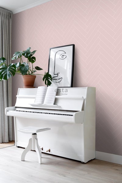 Ein Zimmer mit einer rosafarbenen Tapete im Fischgrätmuster, einem weißen Klavier, einem Hocker und einer Topfpflanze.