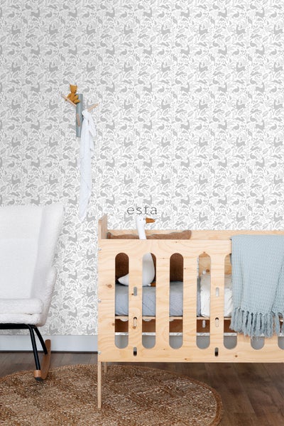 Kinderzimmer mit Holzbett, Sessel und Tapete mit Tiermuster