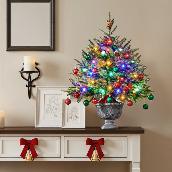 Dekorierter Weihnachtsbaum mit Beleuchtung und Ornamenten auf einem Tisch