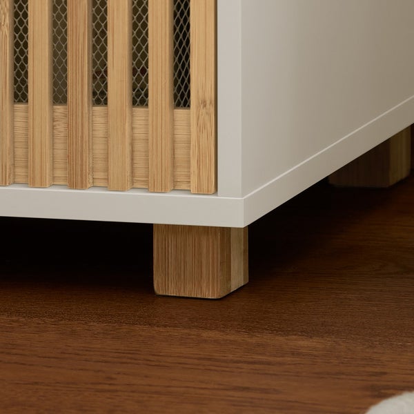 Detailaufnahme eines weißen Schranks mit Bambusfront und Füßen