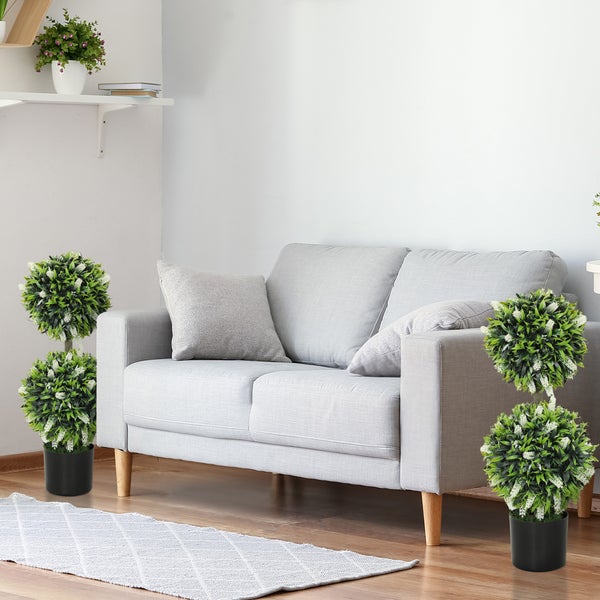 Wohnzimmer mit grauem Sofa und dekorativen Topfpflanzen