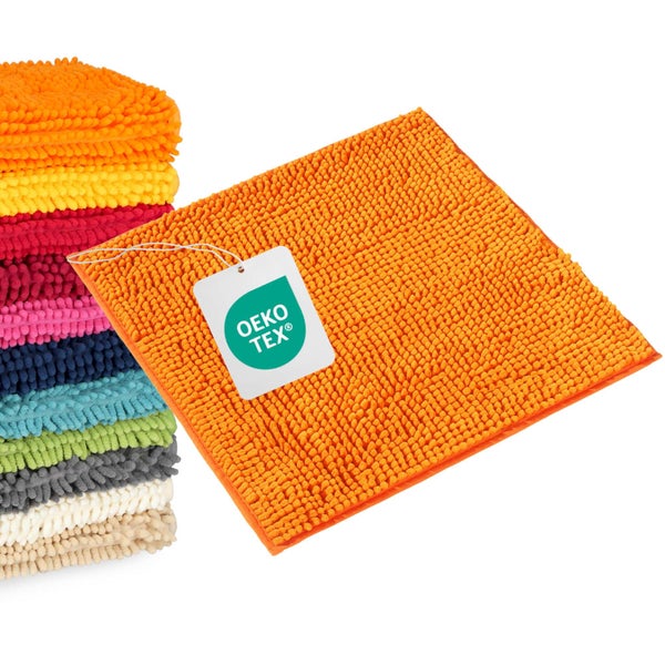 Stapel flauschiger Chenille-Badematten und eine einzelne Matte mit dem Oeko-Tex Logo für schadstoffgeprüfte Textilien.