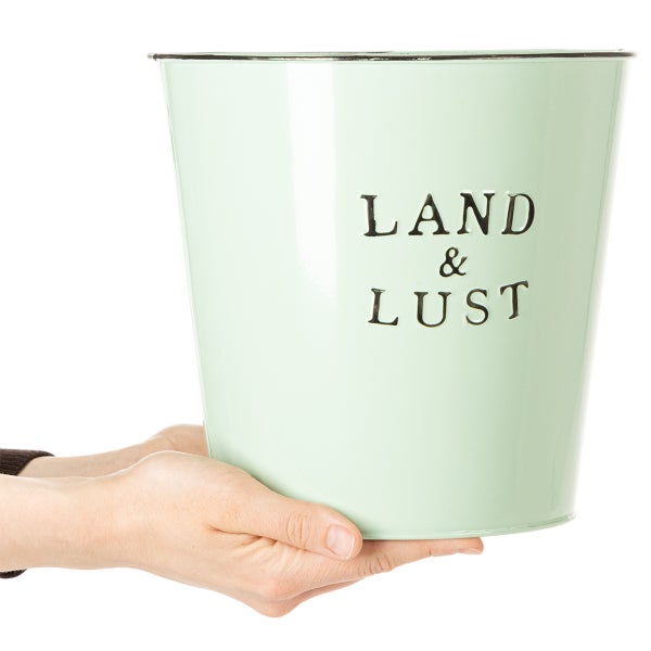 Metall-Übertopf in Hellgrün mit dem Schriftzug Land und Lust, zur Größendarstellung in Händen gehalten