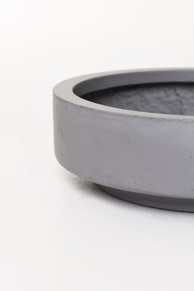 Runder grauer Untersetzer aus Beton für Blumentöpfe in der Detailansicht.