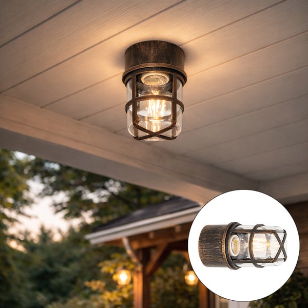 Rustikale Außenleuchte für Wand oder Decke im Industriedesign aus Metall mit Schutzgitter und klarem Glas an einer Holzdecke.