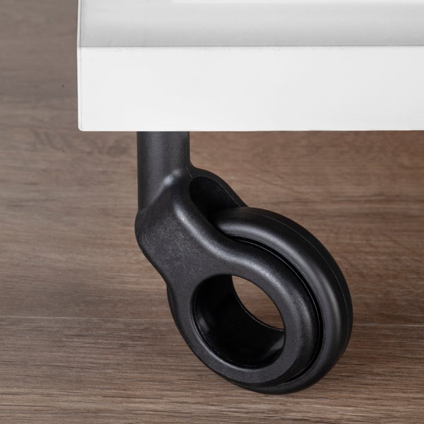 Schwarze Design-Möbelrolle in Ringform an einem weißen Möbelstück auf Holzboden.