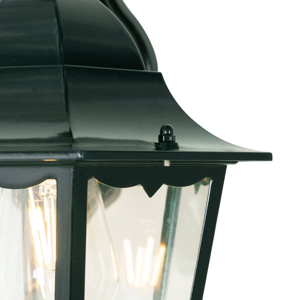 Nahaufnahme einer schwarzen Außenwandleuchte im Laternendesign mit Metallgehäuse, Glaseinsätzen und LED-Filament-Leuchtmittel.