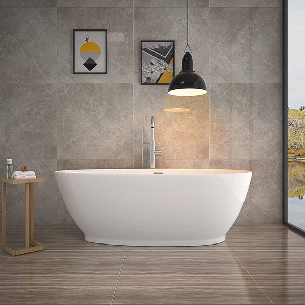 Freistehende Badewanne vor einer Wand mit grauen Fliesen in Steinoptik, ergänzt durch eine Armatur, eine Pendelleuchte und ein Ablagetischchen.
